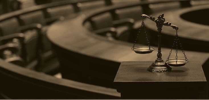 Scales of justice on a bench in a courtroom.